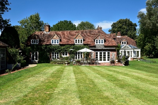 exterior shot of large home with white windows and doors from garden 