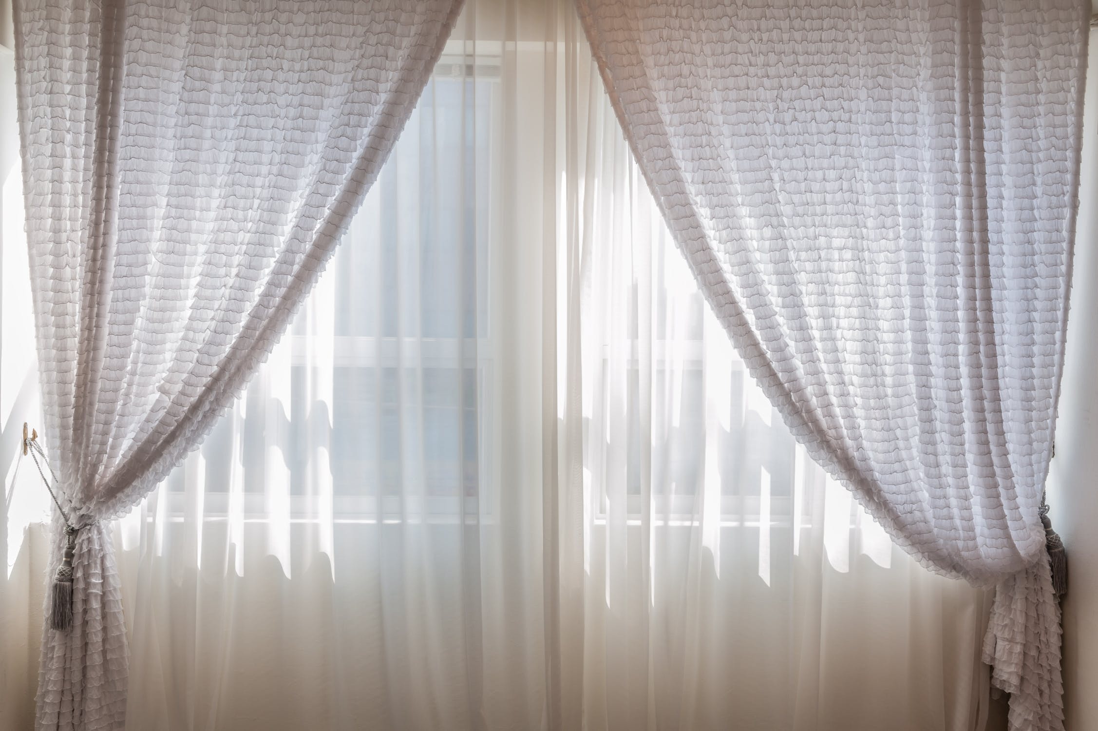 Open curtains with blinds in front.