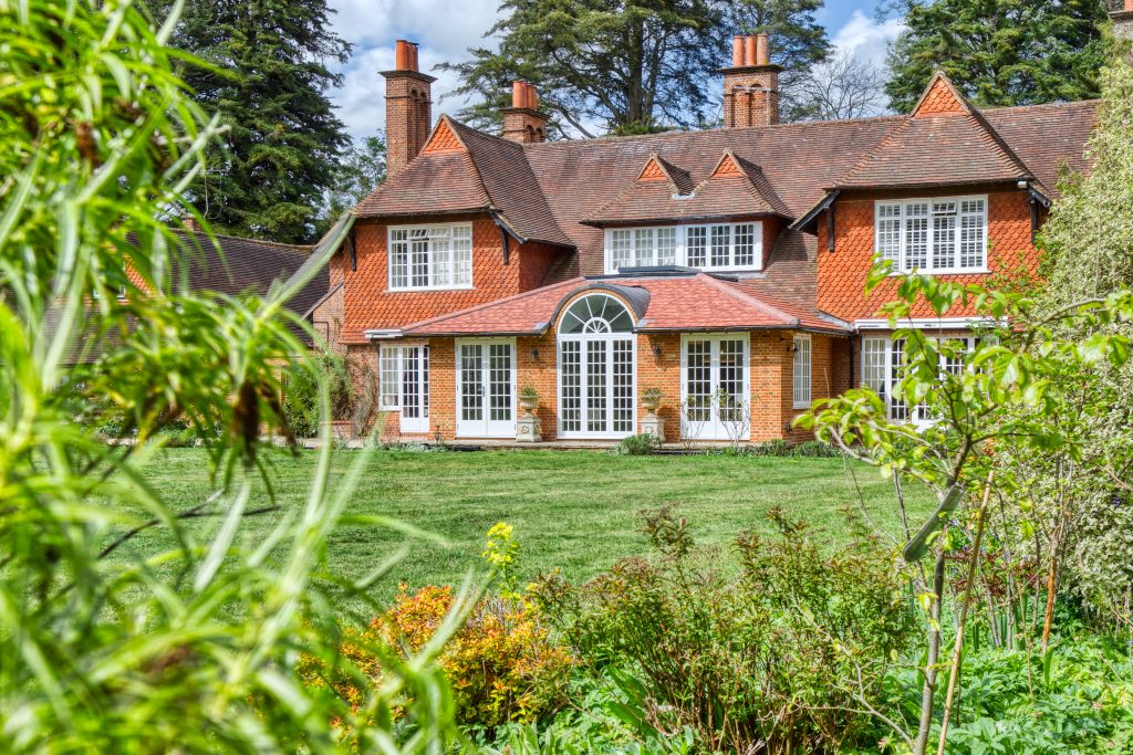 exterior shot from garden, of large country house with white windows and doors