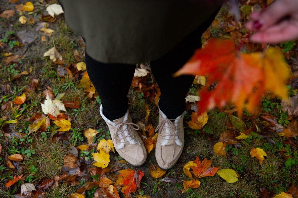 person stood in autumn leaves