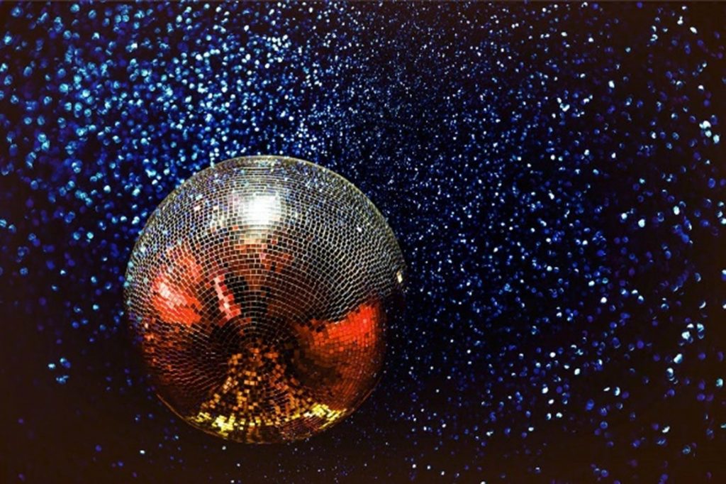 Silver disco ball against a sparkly blue backdrop 