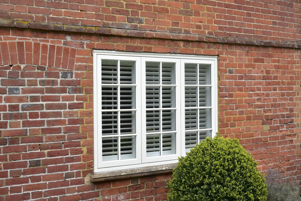 exterior shot of white flush casement window on brick house