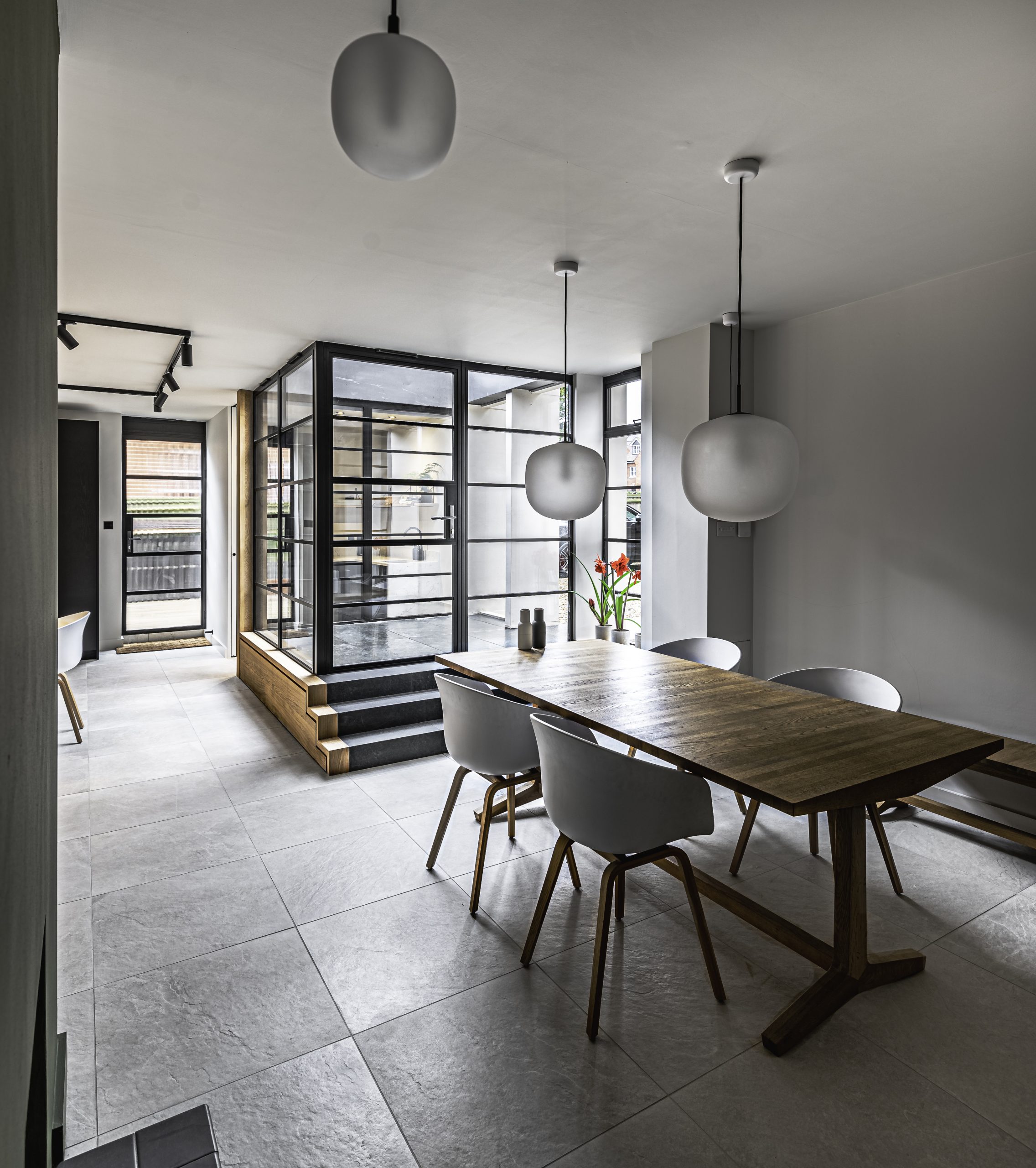 internal view of grey room with table and chairs leading to doorway